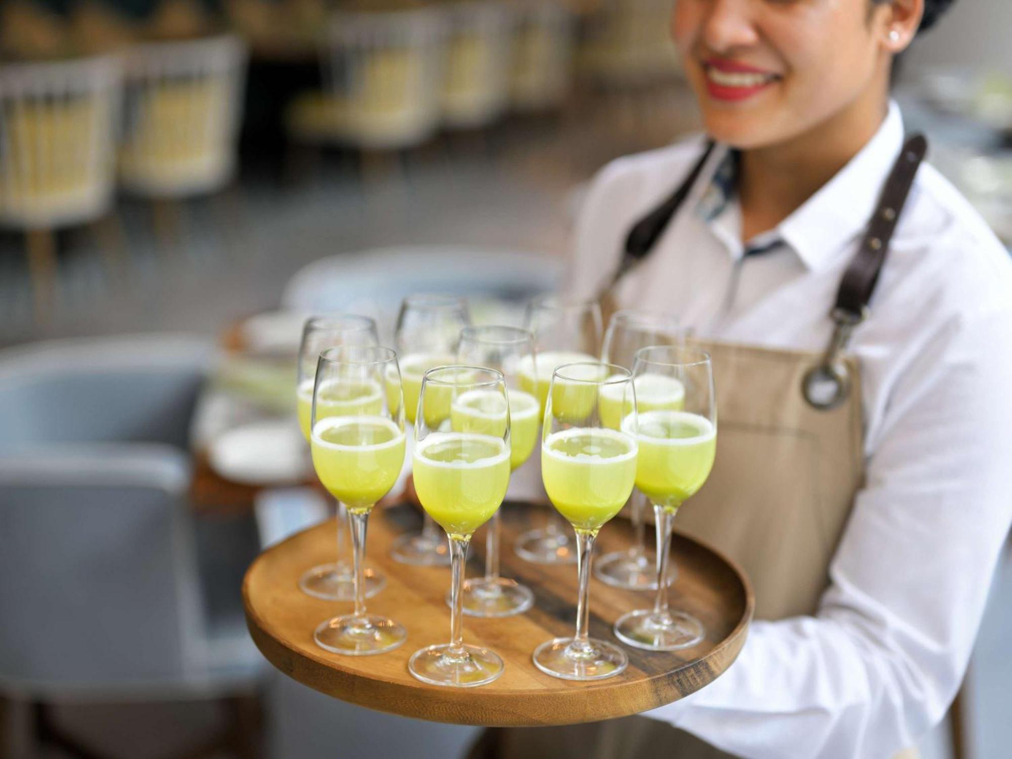 Moevenpick Hotel & Apartments Ghala Maskat Zewnętrze zdjęcie A server holding a tray of cocktails